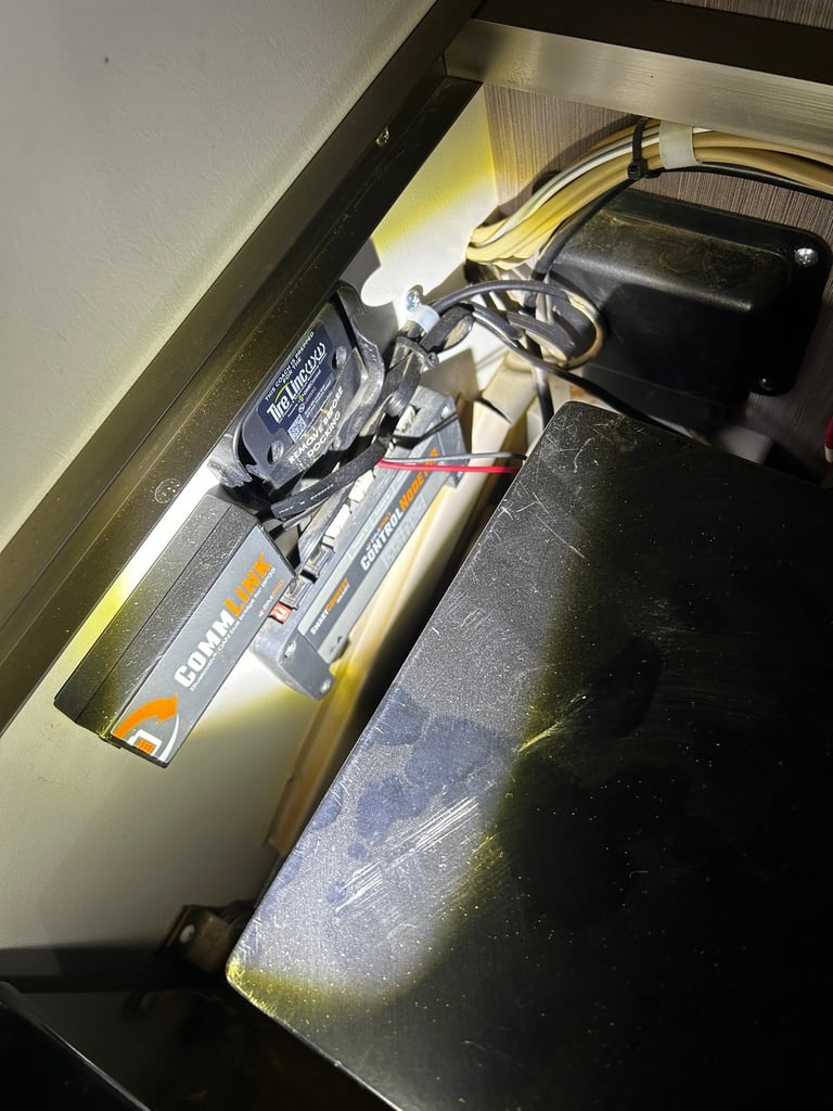 Power adapter and cables stored in a drawer with yellow LED lighting