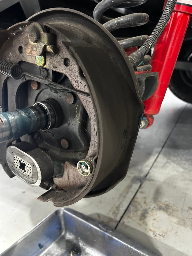 Close-up of a vehicles brake assembly showing the rotor, caliper, and brake pads during maintenance or inspection