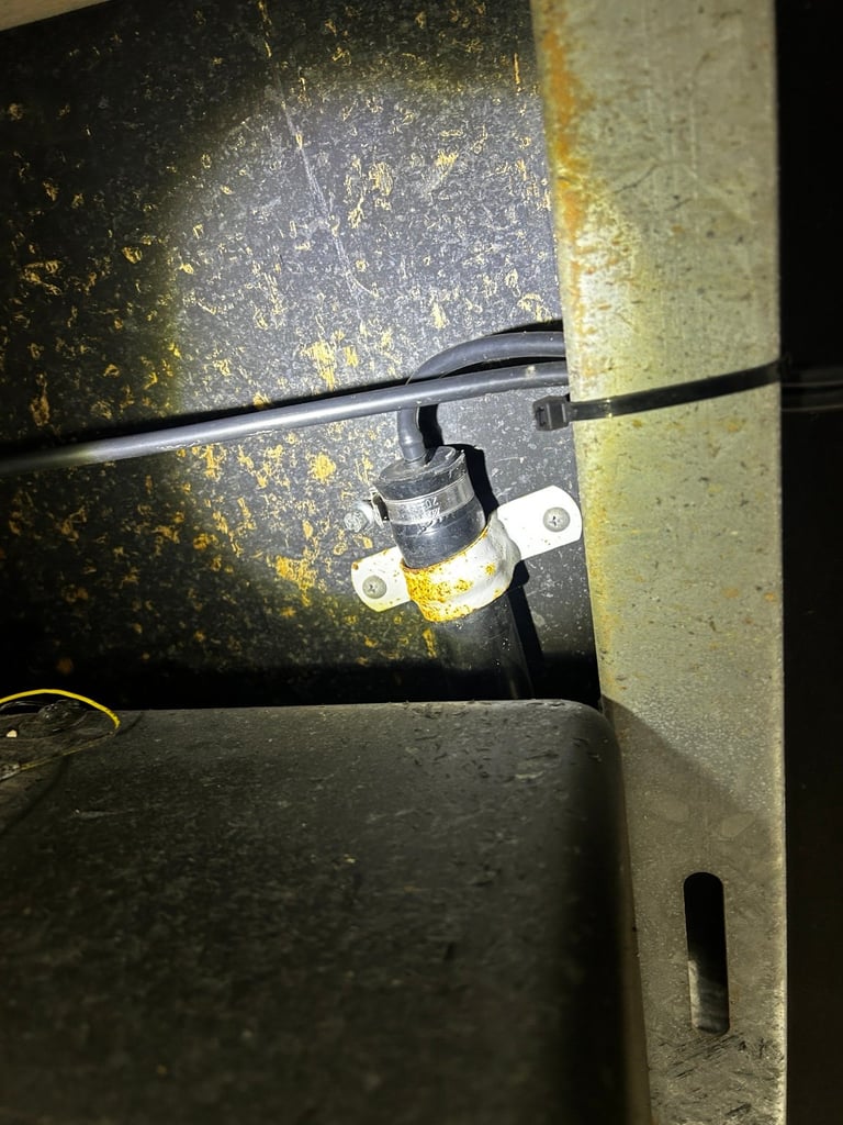 Electrical wiring and conduit bracket mounted on dusty metallic wall surface in industrial setting