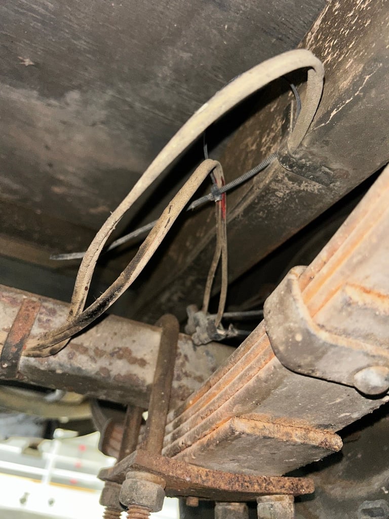 Close-up of a rusty vintage car door handle and latch mechanism on weathered metal