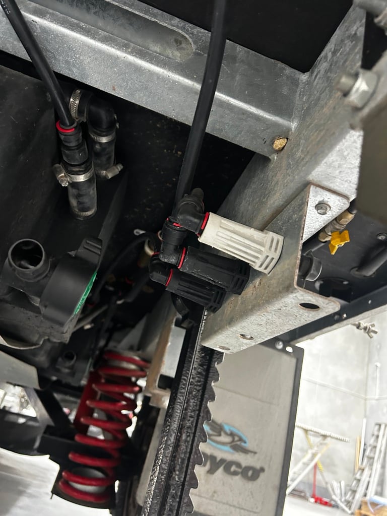 Close-up of vehicle suspension components including coil springs, shock absorbers, and metal chassis parts