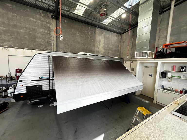 Large white enclosed trailer in an industrial warehouse with metal walls and concrete flooring
