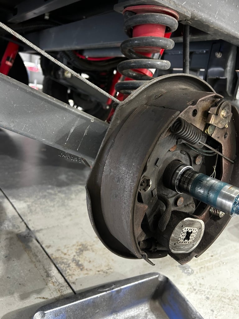 Close-up of a cars brake system showing rotor, caliper, and wheel hub during maintenance or inspection