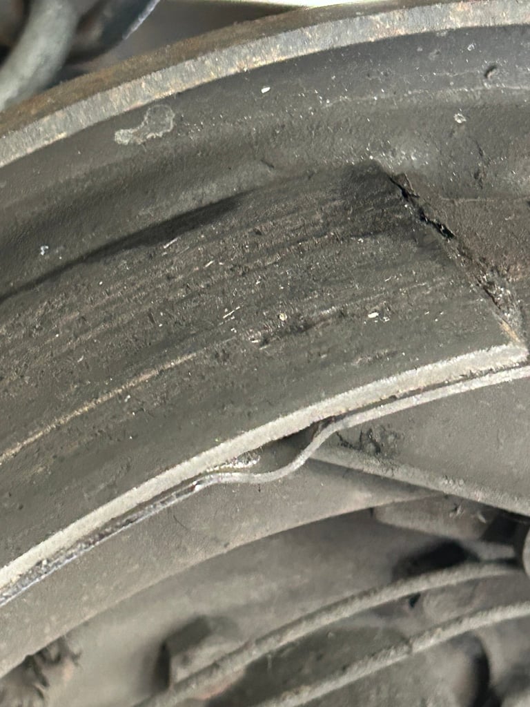 Close-up of stacked brake pads showing wear and dust accumulation on metal surfaces