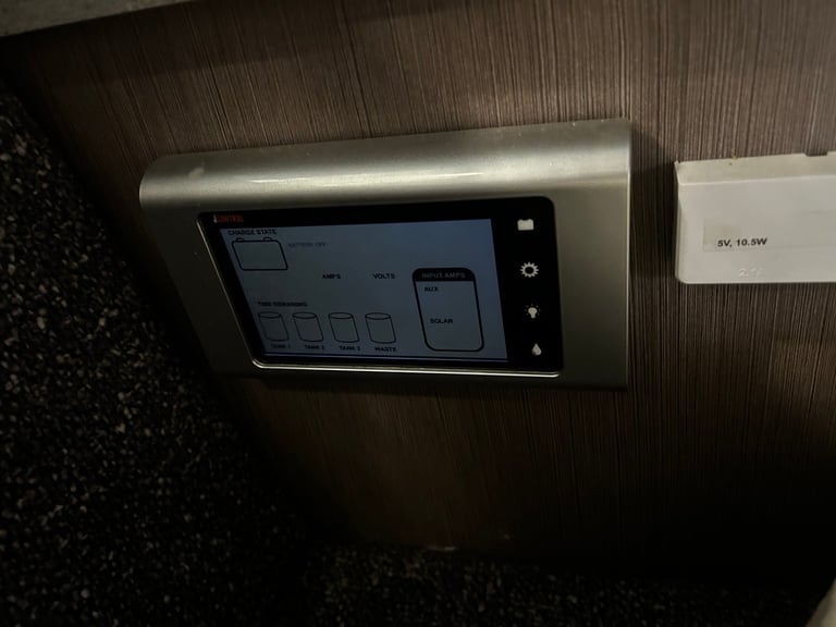 Modern home automation control panel mounted on wall with touchscreen display and metal frame