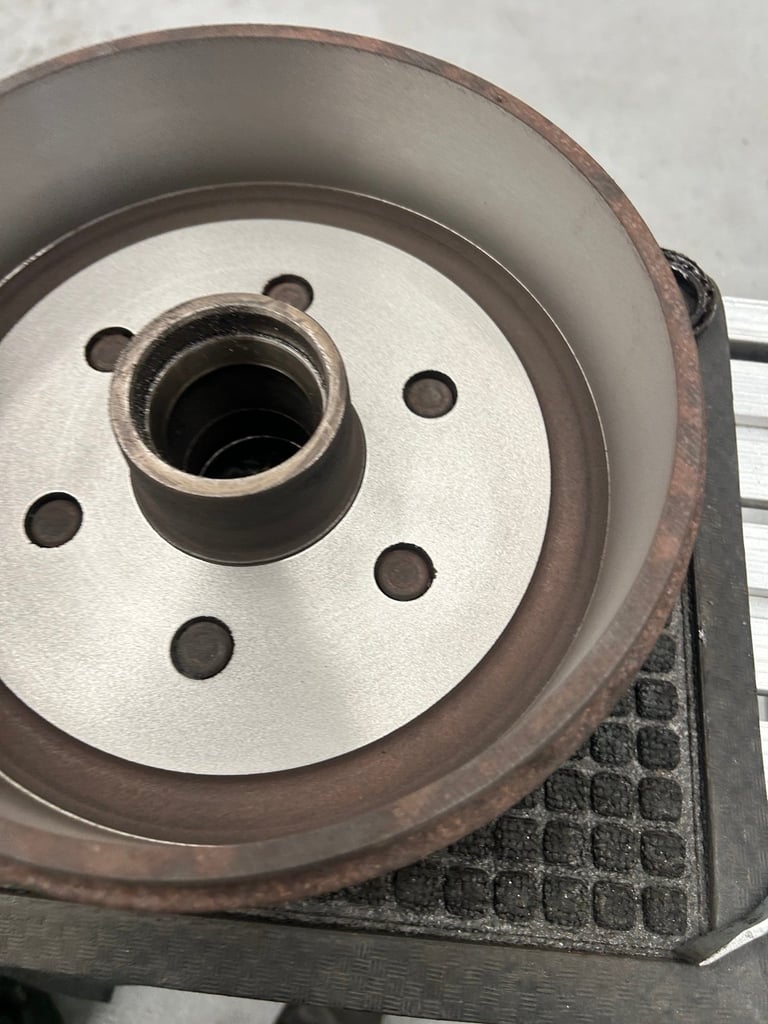 Close-up of a vehicle brake drum and rotor assembly showing wear and rust on the metal components